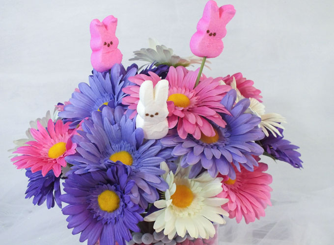 This adorable Easter Centerpiece will be everyone's favorite Easter decoration - so fun and so easy to make. All you need are M&M's, Peeps and some flowers to make this cute DIY Easter Craft. Follow us for more fun Easter ideas.