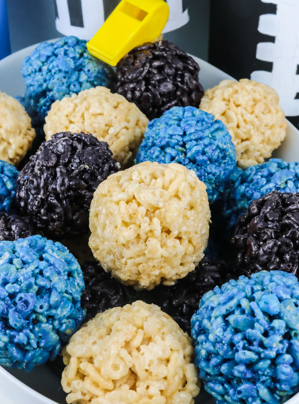 Closeup on a bowl of Carolina Panthers Rice Krispie Bites sitting in front of football decorations.