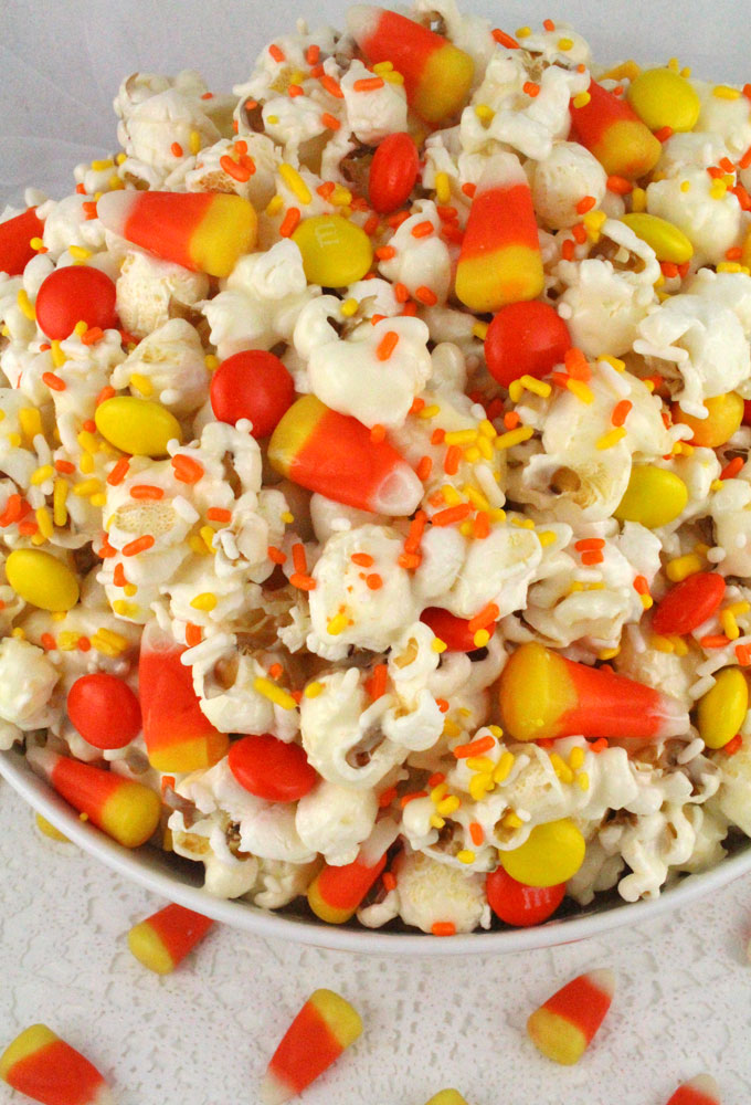 Fall Candy Corn Popcorn - a fun Halloween treat. Sweet, salty, crunchy and delicious and it is so easy to make. It would be a great Halloween Party Food or Fall movie night dessert! Pin this Fall Dessert for later and follow us for more fun Halloween Food ideas.