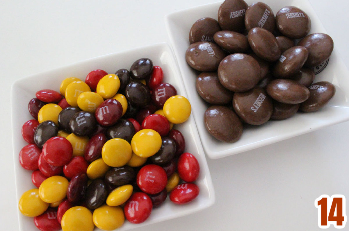Two white ramekins filled with Fall colored M&M's and Hershey's Drops candy.