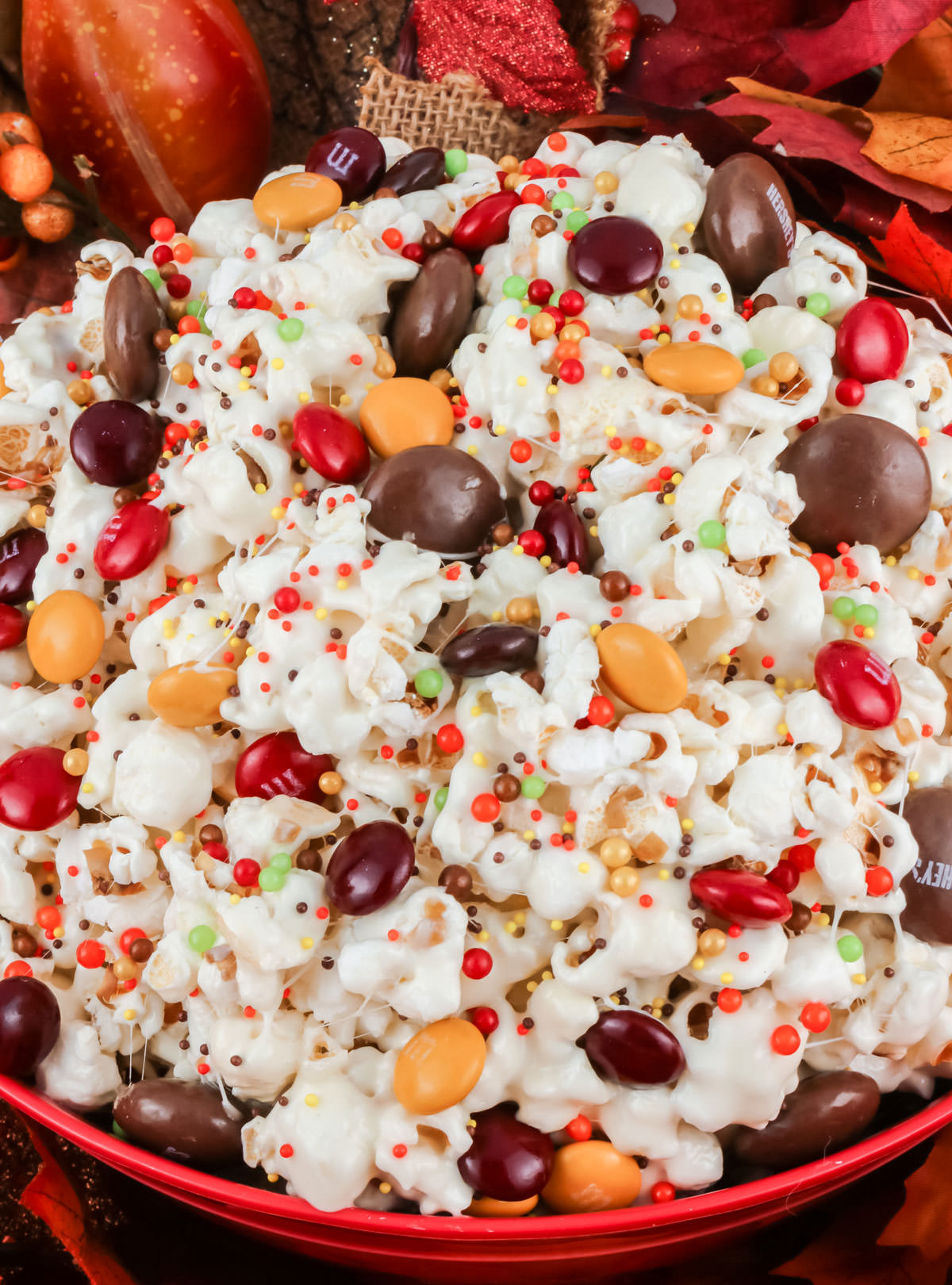 Closeup on a red serving bowl filled with Fall Harvest Popcorn.