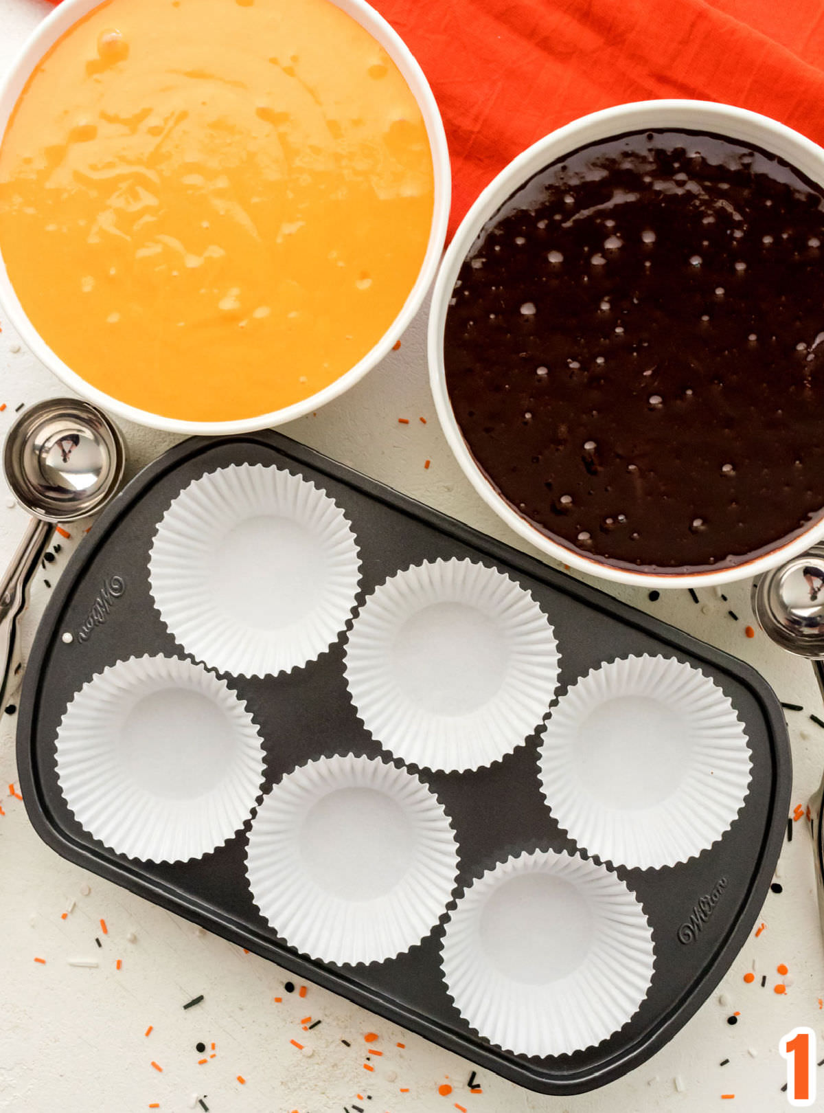 Closeup of two white bowls, one filled  with cake batter and the other with brownie mix.