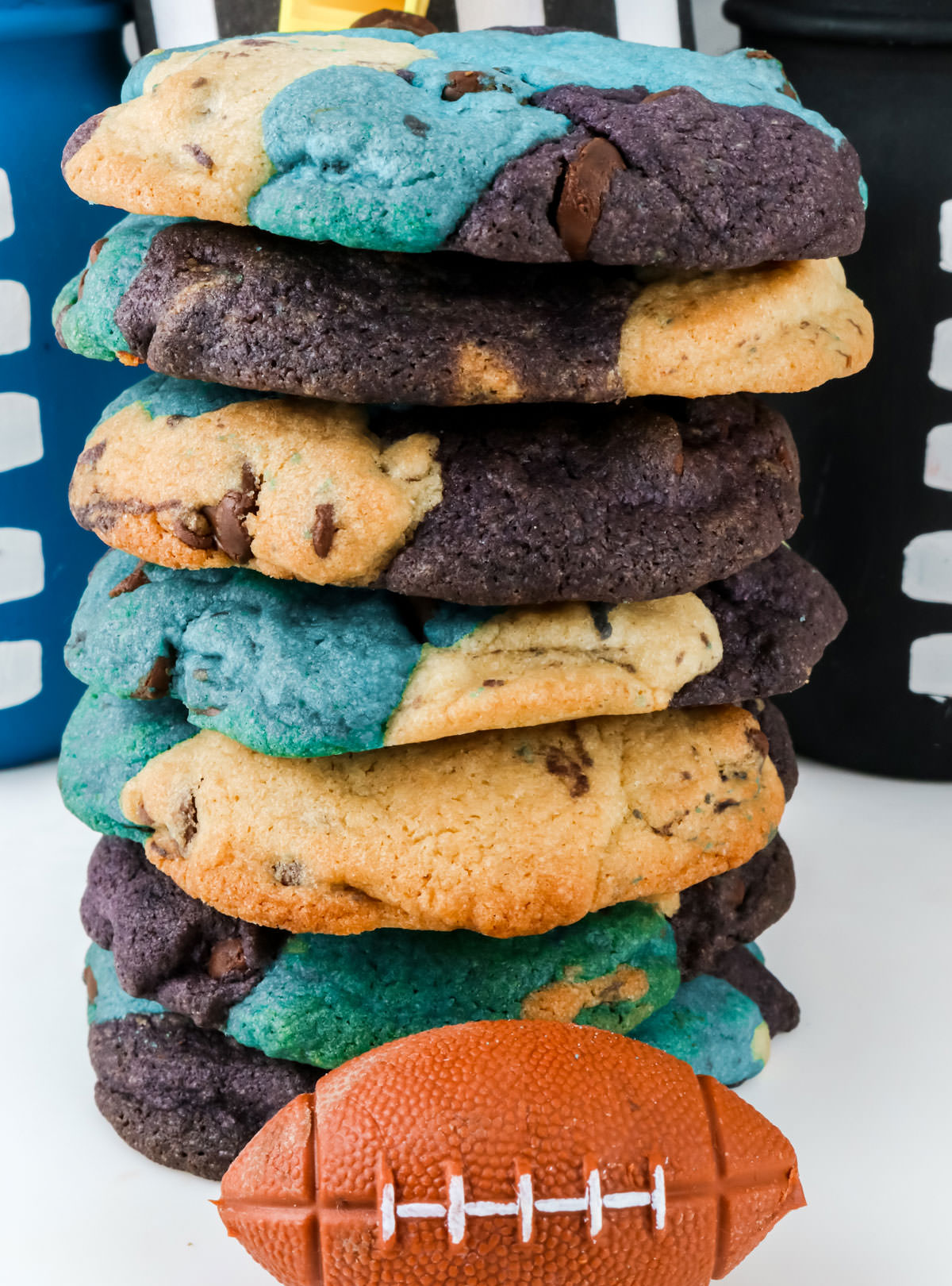 Closeup on a stack of Carolina Panthers Chocolate Chip Cookies sitting on a white table in front of football decorations.
